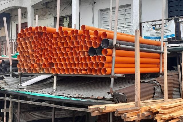 Stacks of new plastic water and drain pipes ready for installation